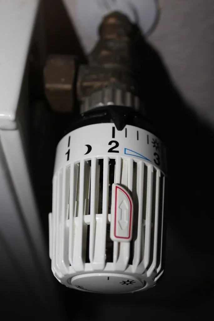 Radiator thermostat valve beside a heating panel